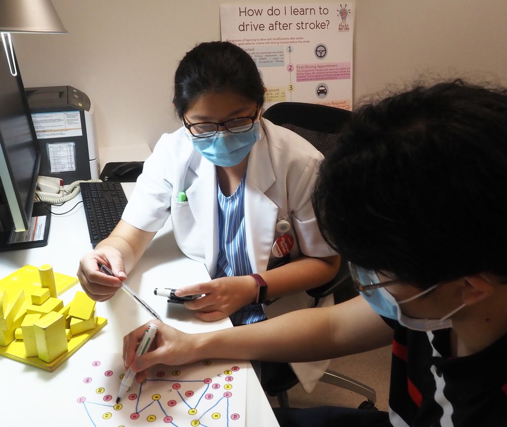 Senior occupational therapist Lim Hui Hui (left) assessing a client's cognition and visual perceptual abilities before giving an approval for him to learn driving. — TTSH pic