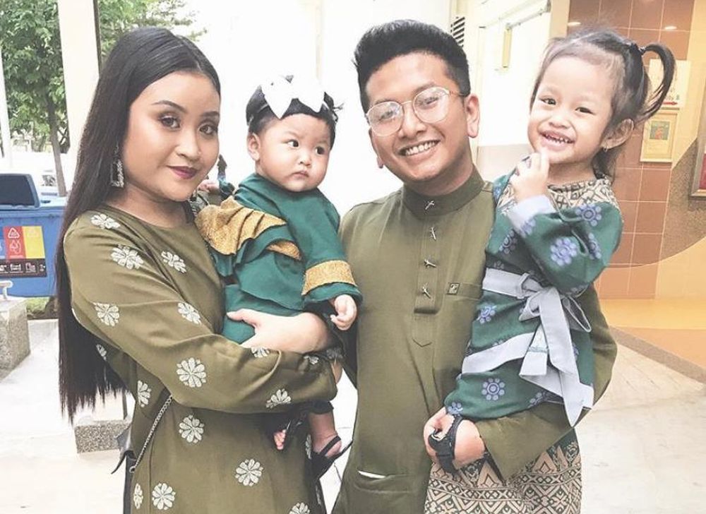 Khairul Khamari with his family in an older photo. He cannot lift up his left arm but is able to carry his daughter in a fixed position. — Picture by Khairul Khamari