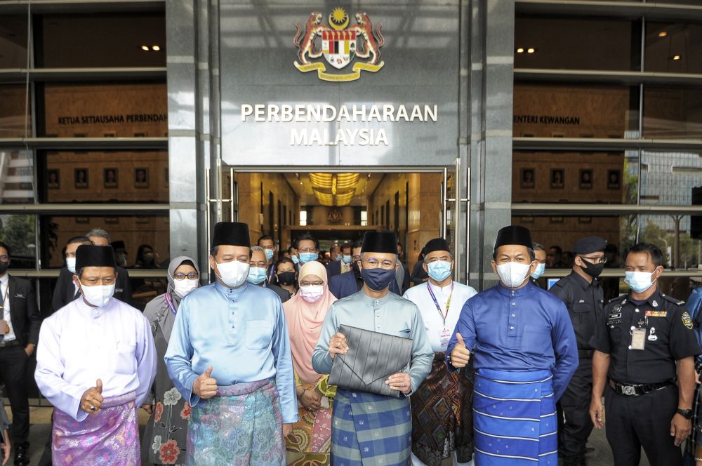 Datuk Seri Tengku Zafrul Abdul Aziz (third from left) poses for cameras outside the Finance Ministry before leaving for Parliament to table Budget 2021 November 6, 2020. u00e2u20acu201d Picture by Shafwan Zaidon