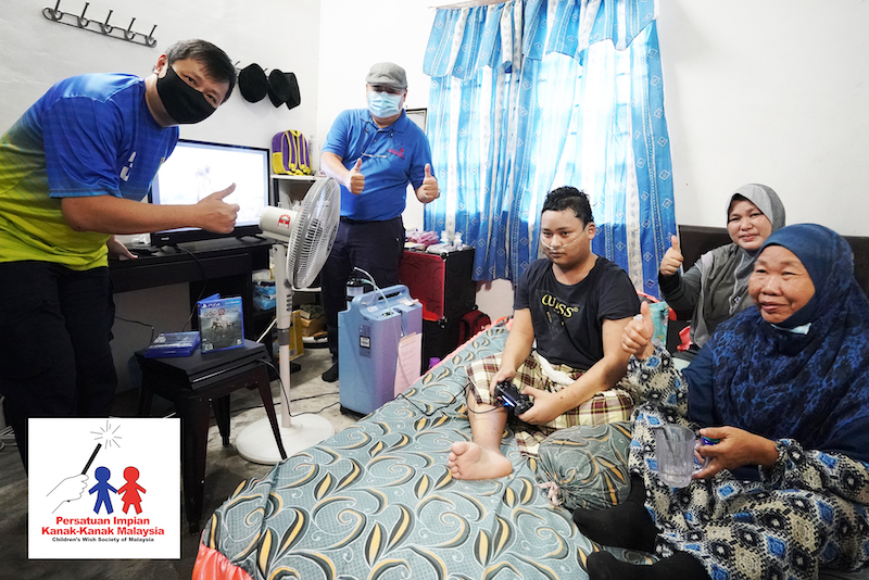 Cancer patient Muhammad Hamizan Ashari (centre) receives a PS4 Pro game console and a TV set from the Childrenu00e2u20acu2122s Wish Society of Malaysia. u00e2u20acu201d Picture courtesy of Childrenu00e2u20acu2122s Wish Society of Malaysia