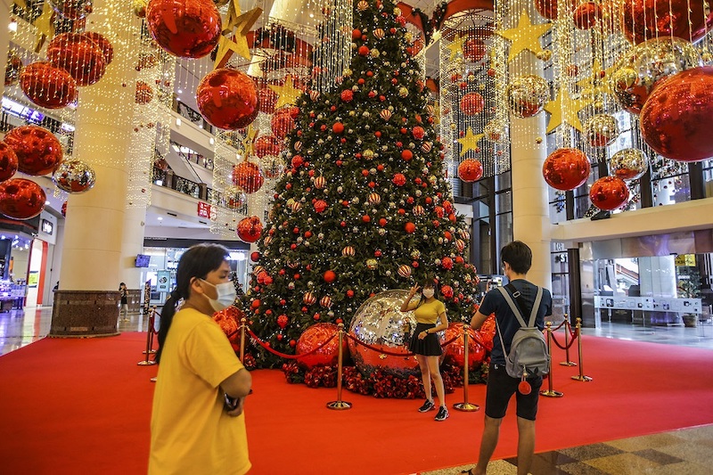 Shoppers pose with the giant red and gold baubles at Berjaya Times Square’s concourse. — Picture by Hari Anggara