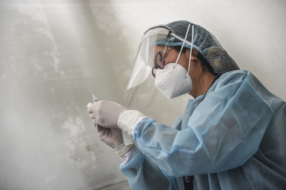 A health worker prepares a syringe to inoculate a volunteer with a Covid-19 vaccine produced by the Chinese Sinopharm during its trial at the Clinical Studies Center of the Cayetano Heredia University in Lima December 9, 2020. u00e2u20acu201d AFP pic