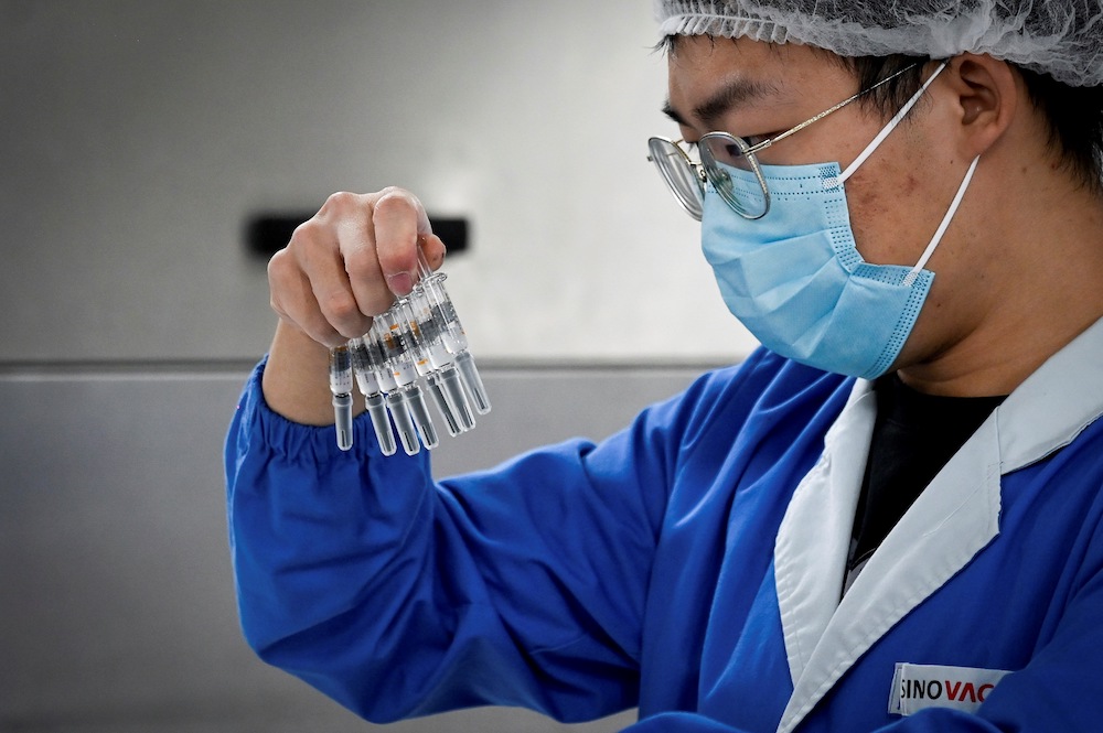 This file photo taken on September 24, 2020 shows a staff member checking vaccines during a media tour of a new factory built to produce a Covid-19 coronavirus vaccine at Sinovac in Beijing. u00e2u20acu201d AFP pic