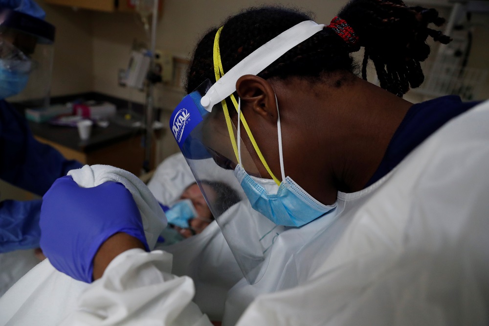 Patient Care Technician Fanta Keita treats Donna Plummer, a coronavirus disease (COVID-19) positive patient, as she lays on the emergency room bed at Roseland Community Hospital on the South Side of Chicago, Illinois December 2, 2020. u00e2u20acu201d Reuters pic
