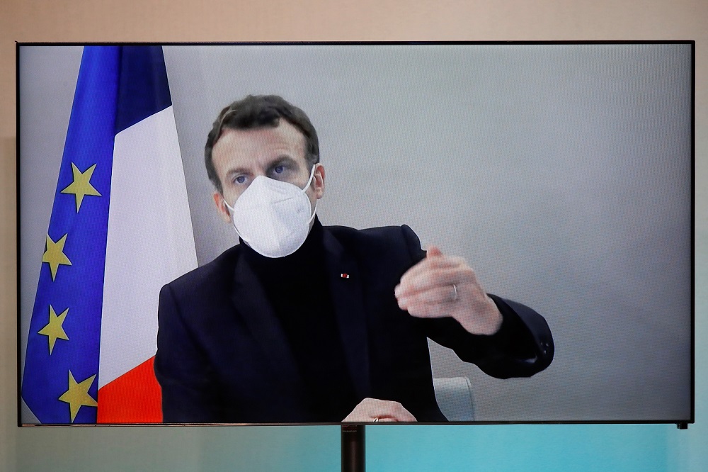 French President Emmanuel Macron is seen on a screen as he attends by video conference a round table for the National Humanitarian Conference (NHC) at the Foreign Affairs Ministry in Paris December 17, 2020. u00e2u20acu201d Reuters pic