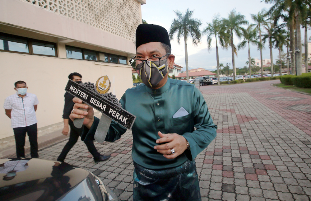 Datuk Seri Ahmad Faizal Azumu removes the Perak Mentri Besar sign from his car at the Perak Mentri Besar House in Ipoh December 5, 2020. u00e2u20acu201d Picture by Farhan Najib