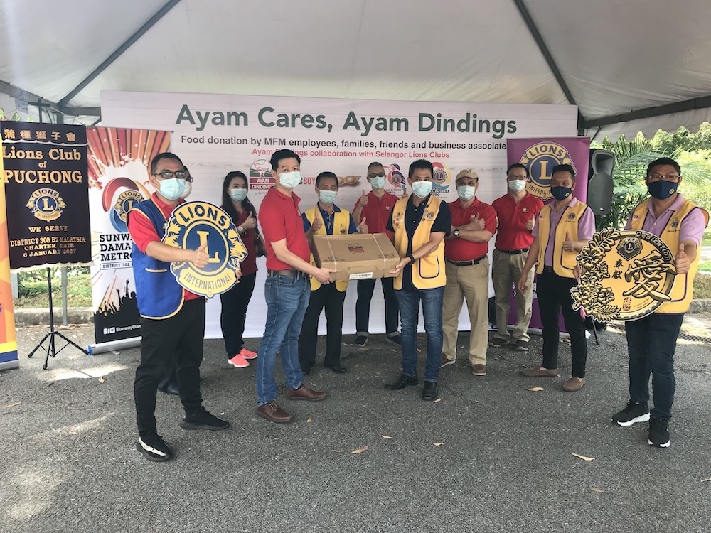 Lions Club Puchong, Vice District Governor, Loy Kwee Keow (mid-left) presenting banner to MFM Supply Chain General Manager, Wong Kok Wai (mid-right). u00e2u20acu201dPhoto courtesy of Lions Club Puchong
