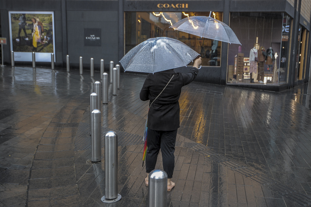 An umbrella vendor holding umbrellas during the rain in Bukit Bintang, Kuala Lumpur December 10, 2020. u00e2u20acu201d Picture by Shafwan Zaidon