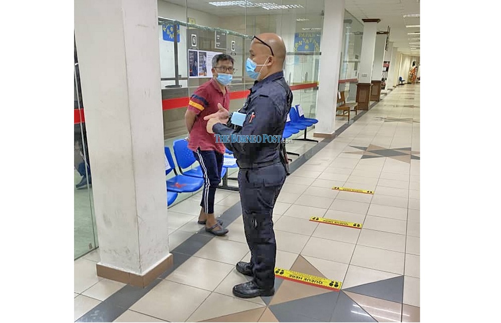 The accused (left) at the Kuching Court complex yesterday. u00e2u20acu201d Borneo Post Online