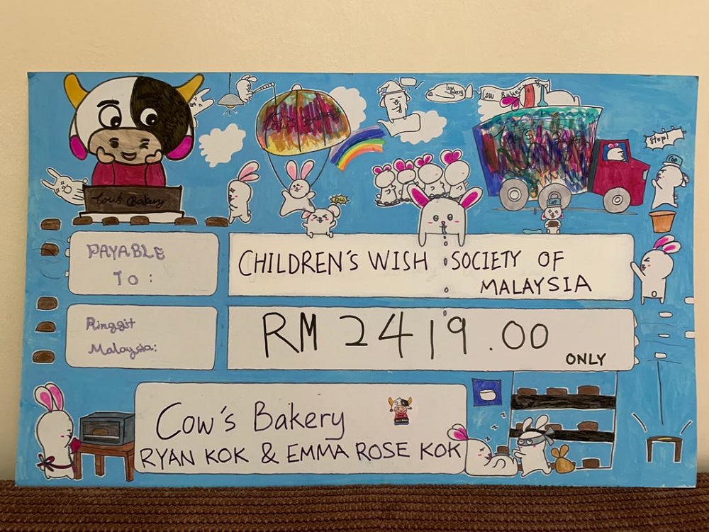 Emma personally designed the mock cheque to mark the occasion. — Picture courtesy of Ng Si Hooi