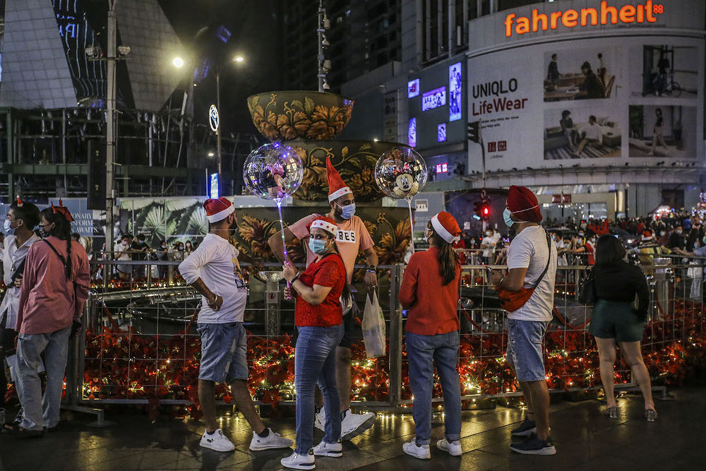 Shoppers dressed in Christmas outfits are seen in front of the Pavilion Kuala Lumpur December 24, 2020. — Picture by Hari Anggara