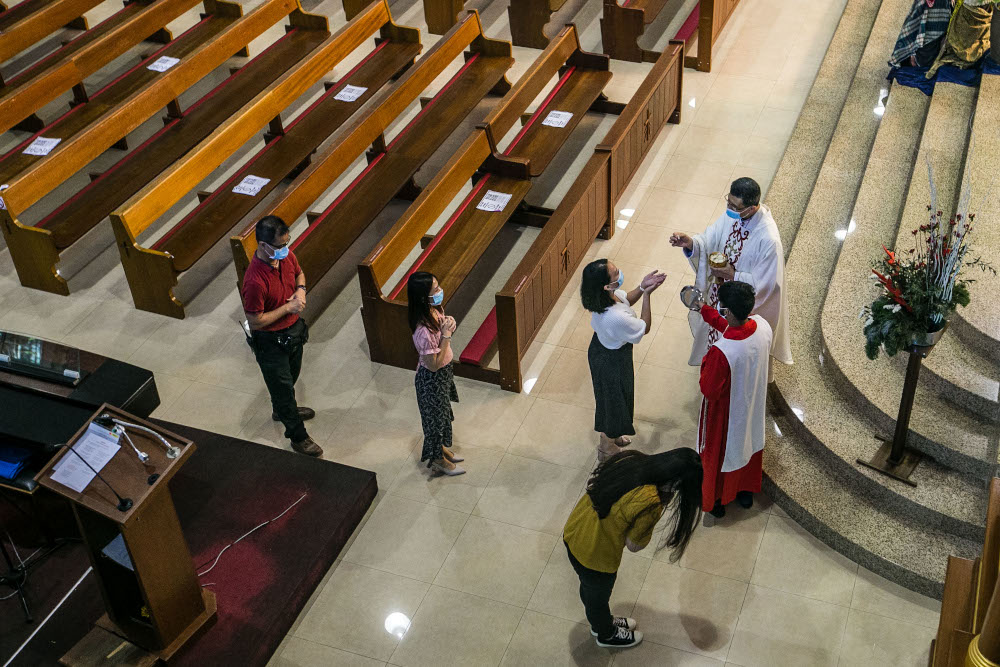 Churchgoers receive communion during Christmas mass at the Church of Divine Mercy in Shah Alam December 25, 2020. — Picture by Firdaus Latif