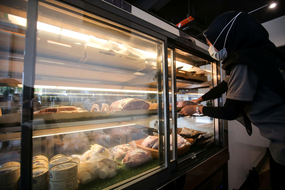 A worker arranging imported frozen meat at a meat shop in Ipoh December 28, 2020. News of imported meat that was improperly sourced and passed off as halal recently made headlines. — Picture by Farhan Najib