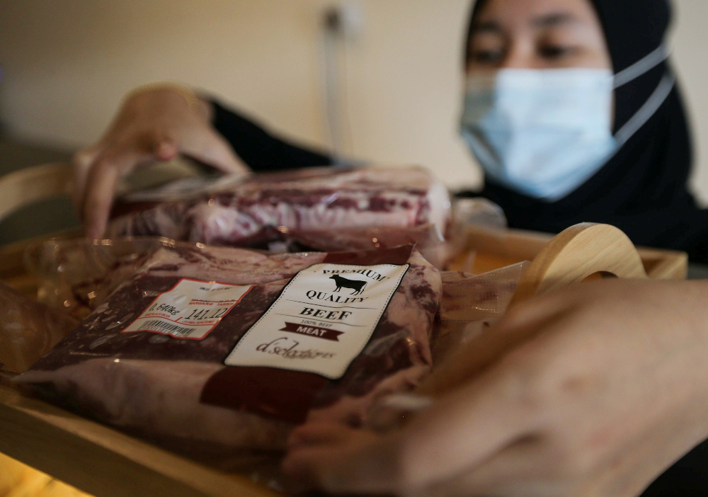 A worker arranging imported frozen meat at a meat shop in Ipoh December 28, 2020. News of imported meat that was improperly sourced and passed off as halal recently made headlines. — Picture by Farhan Najib