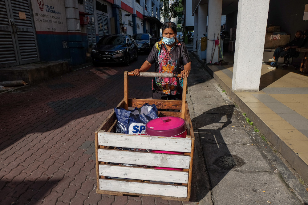 Food vendor Lilly Anthonysamy pushes her cart across a street in Kuala Lumpur December 28, 2020. 