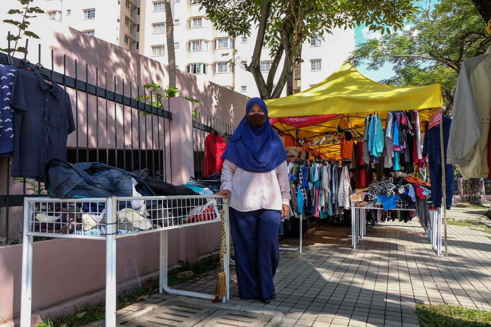 Sazarina Bakri who sells used clothing poses for a picture at her roadside stall in Kuala Lumpur December 28, 2020. 