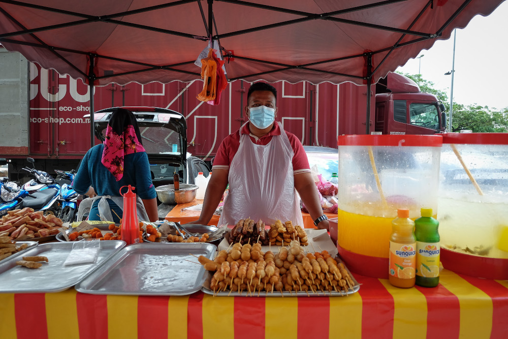 Food vendor Junas Azizi Muhammad Nasir, 37, poses for a pictures at his roadside stall in Kuala Lumpur December 28, 2020. 