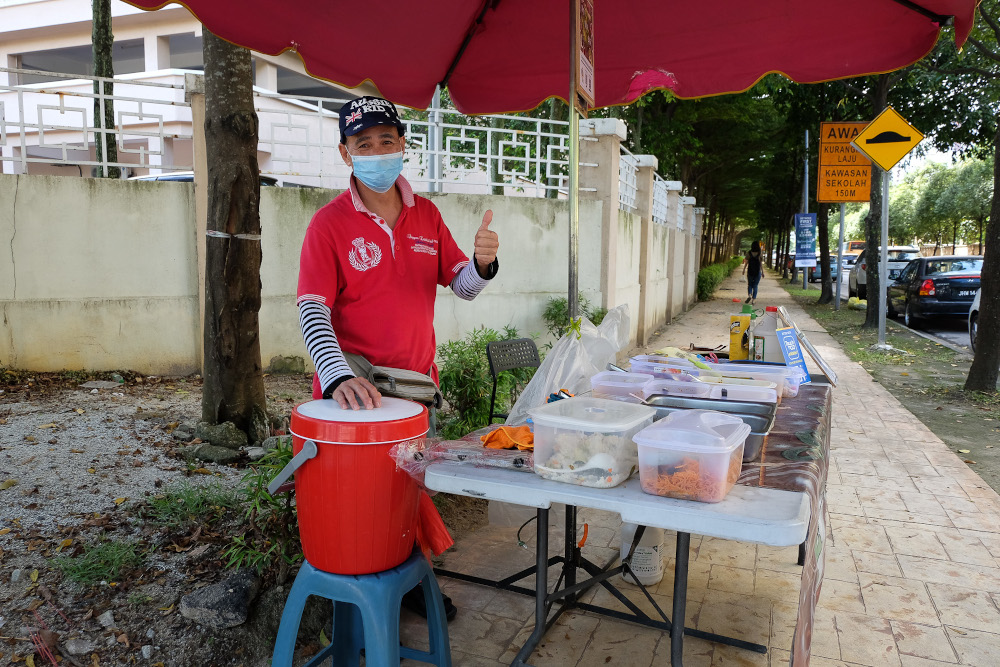 Food vendor Alex Chau, 59, poses for a picture at his roadside stall in Kuala Lumpur December 28, 2020. 