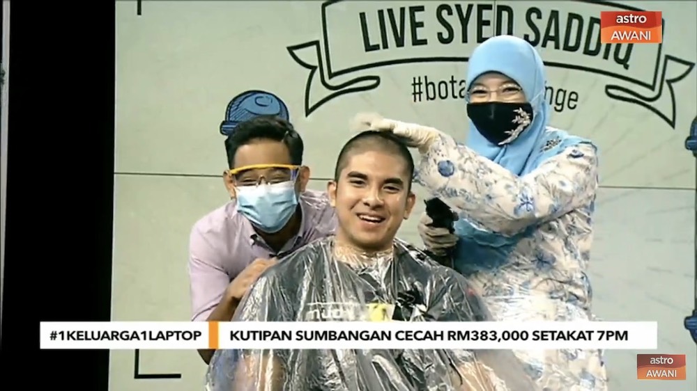 Syed Saddiq puts on a game face as his head is shaved. u00e2u20acu201d Screencap via AstroAwani/Twitter