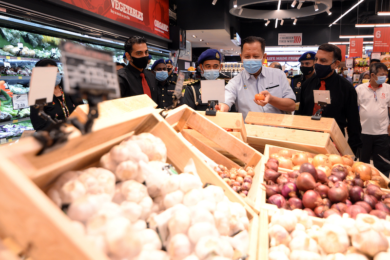 Trade, Industry and Entrepreneurial Development Committee chairman Datuk Abdul Halim Hussain (middle) checking on prices of goods at Sam's Groceria, Penang. u00e2u20acu201d Picture by Steven Ooi K.E.