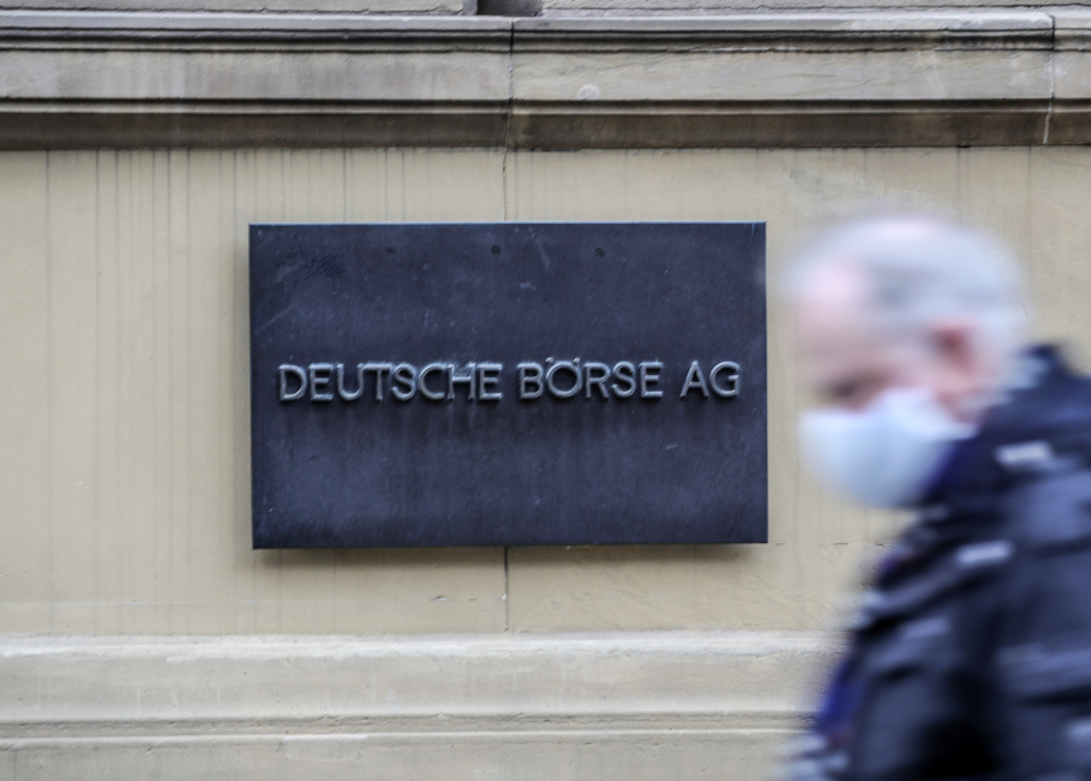 A man wearing a face mask passes next to the sign of the Deutsche Boerse AG at the stock exchange in Frankfurt am Main, western Germany, December 28, 2020 as the stock index DAX reached a record high. u00e2u20acu201d AFP pic