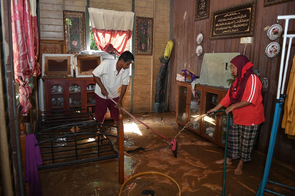 Flood victims are seen cleaning their house at Kampung Teladas, Air Putih near Kemaman November 29, 2020. u00e2u20acu201d Bernama pic