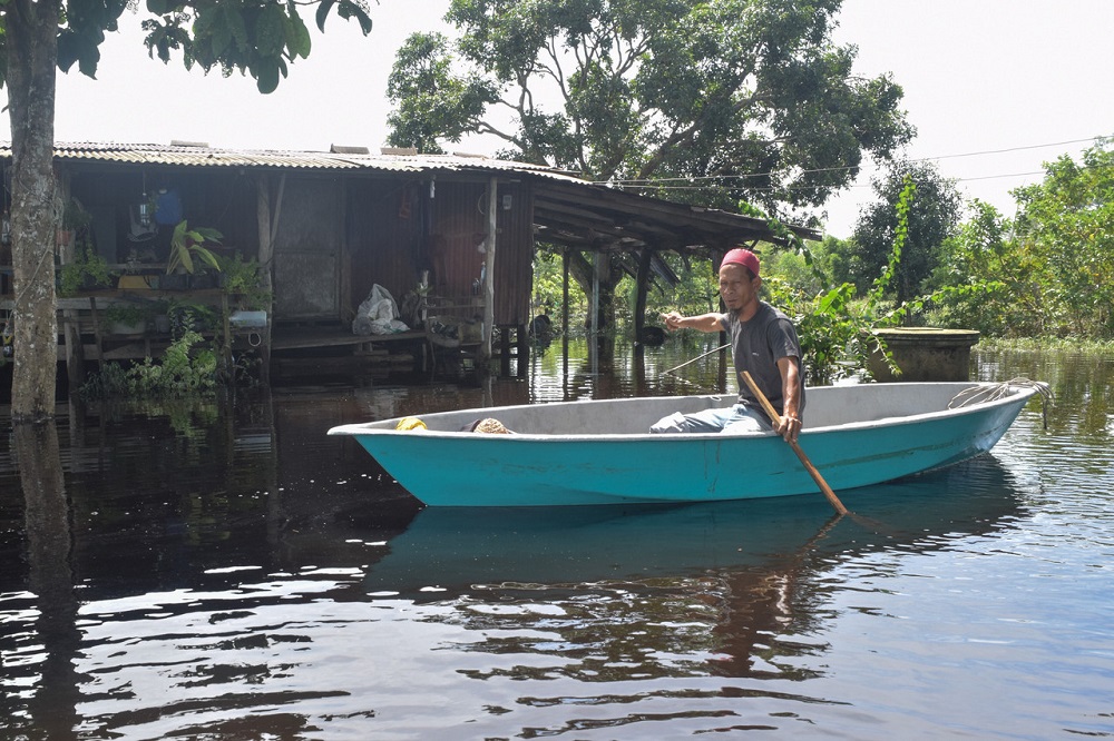A man rows a boat in floodwater as he examines the damage caused by the flood in Kampung Pasir Puteh in Marang November 29, 2020. u00e2u20acu201d Bernama pic