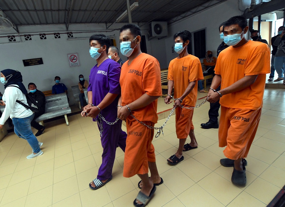 The four suspects are led out of the Kangar High Court in handcuffs December 2, 2020. u00e2u20acu201d Bernama pic