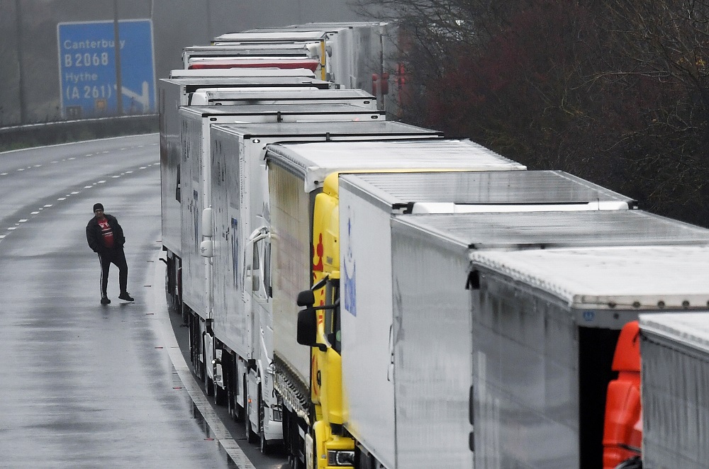 A driver walks next to lorries parked on the M20 motorway towards Eurotunnel and the Port of Dover, as EU countries impose a travel ban from the UK following the coronavirus disease outbreak, in Folkestone, Britain December 21, 2020. u00e2u20acu2022 Reuters pic