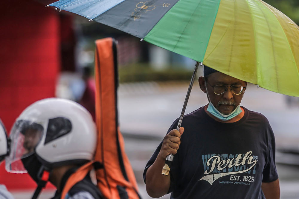 People using their umbrellas after a rainstorm in Kuala Lumpur December 3, 2020. u00e2u20acu201d Picture by Hari Anggara
