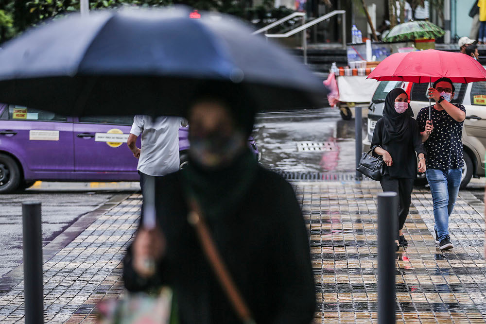 People using their umbrellas after a rainstorm in Kuala Lumpur December 3, 2020. u00e2u20acu201d Picture by Hari Anggara