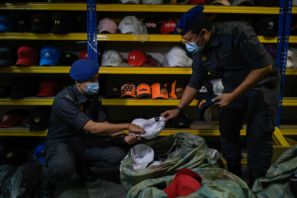 Enforcement officers from the Ministry of Domestic Trade and Consumer Affairs inspect counterfeit goods in Kuala Lumpur, December 3, 2020. — Bernama pic