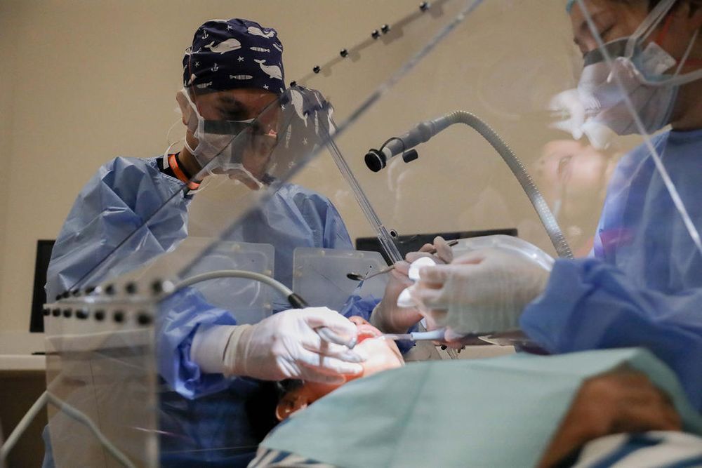 Dr Intekhab Islam (left) from NUS Faculty of Dentistry demonstrates the Dental Dart for a safer dental care for Covid-19 in a clinical setting at the National University Centre For Oral Health Singapore on Dec 21, 2020. u00e2u20acu201d TODAY pic