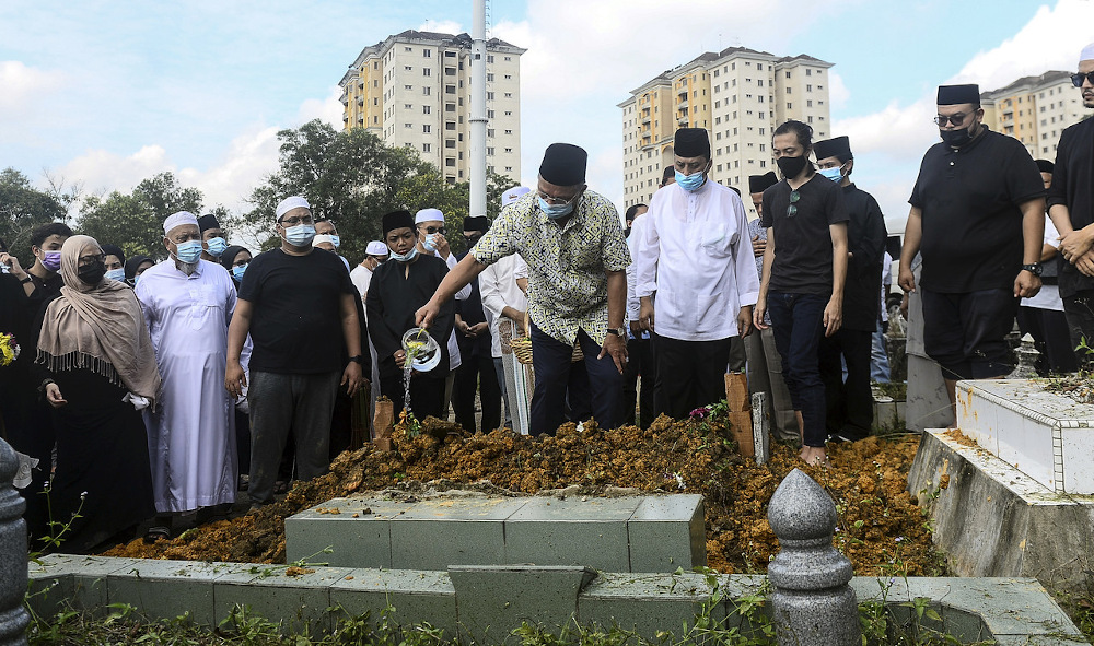 Johor Mentri Besar Datuk Hasni Mohammad sprinkles rose water on the grave of former Johor Speaker Tan Sri Mohamad Aziz in Johor Baru December 25, 2020. u00e2u20acu201d Bernama pic
