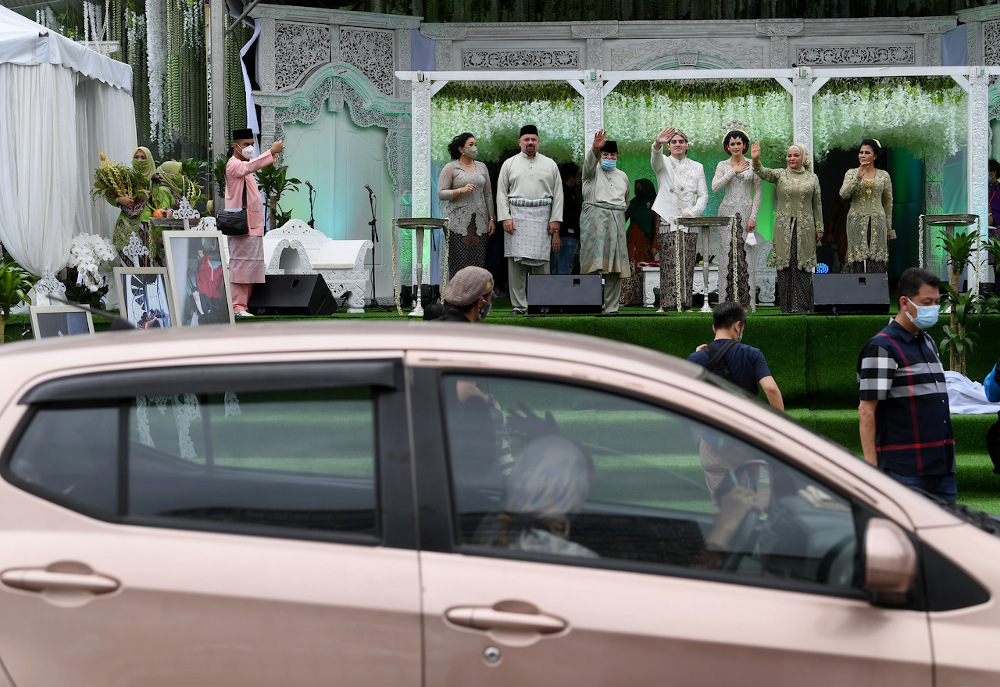 Datuk Seri Tengku Adnan Mansor (5th right), his wife Datin Seri Anggraini Sentiyaki (2nd right), the groom Tengku Muhammad Hafiz (centre) and bride Oceane Cyril Alogia (3rd right) wave to guests at Dataran Putrajaya December 20, 2020. u00e2u20acu201d Bernama pic