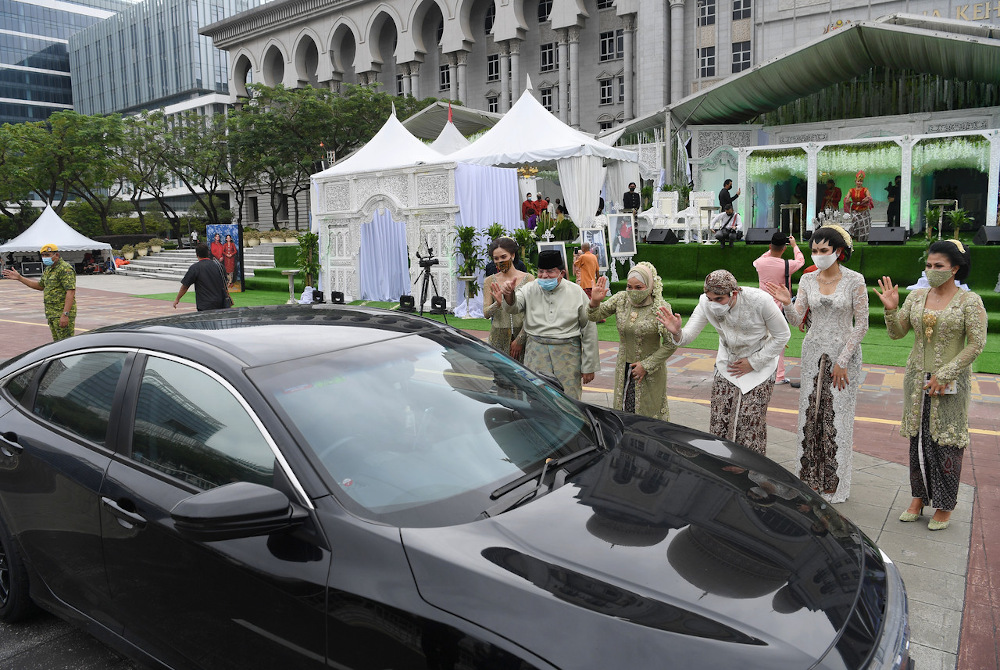 Datuk Seri Tengku Adnan Mansor (5th right), his wife Datin Seri Anggraini Sentiyaki (4th right), his son Tengku Muhammad Hafiz (centre) and daughter-in-law Oceane Cyril Alogia (2nd right) wave to guest at Dataran Putrajaya December 20, 2020. — Bernama p