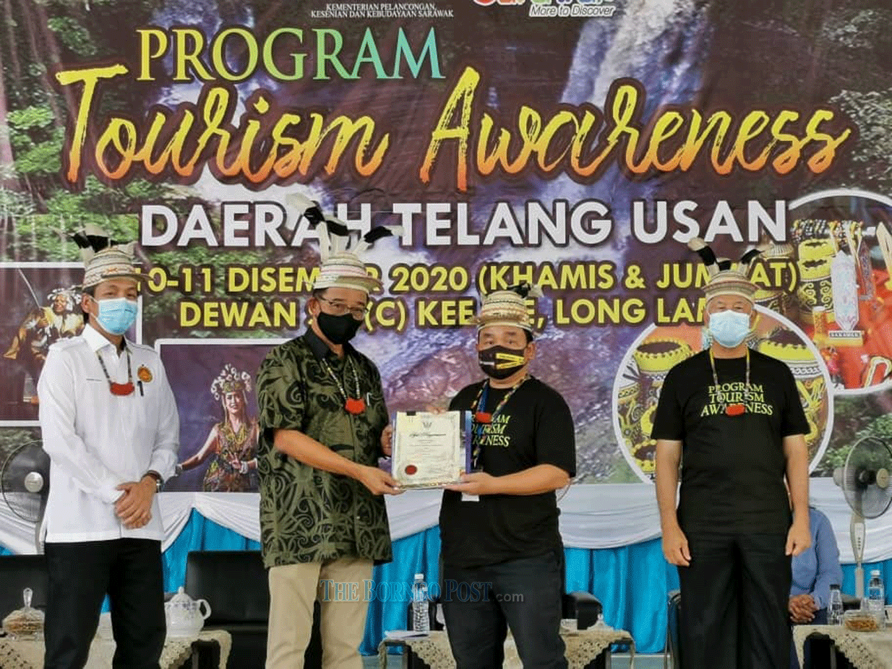 Minister of Tourism, Arts and Culture Datuk Abdul Karim Rahman Hamzah (second, left) presents a certificate of participation to one of the programme participants. On the left is Telang Usan assemblyman Dennis Ngau. u00e2u20acu2022 Borneo Post pic