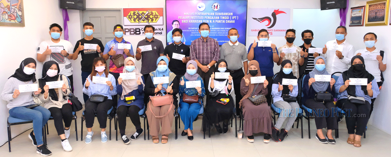 Dr Abdul Rahman (standing, sixth left) joins the students in a group photo at his Pantai Damai service centre. u00e2u20acu201d Picture by Muhammad Rais Sanusi via Borneo Post