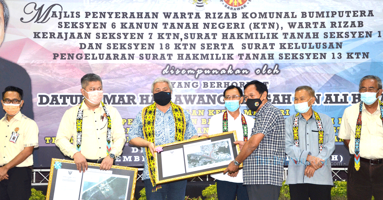 Sarawak Deputy Chief Minister Datuk Amar Awang Tengah Ali Hasan (third, left) presents the Bumiputera Communal Reserve Gazette for traditional village to Kampung Baru Laut chief Sikong Lusek as others look on. u00e2u20acu2022 Borneo Post pic