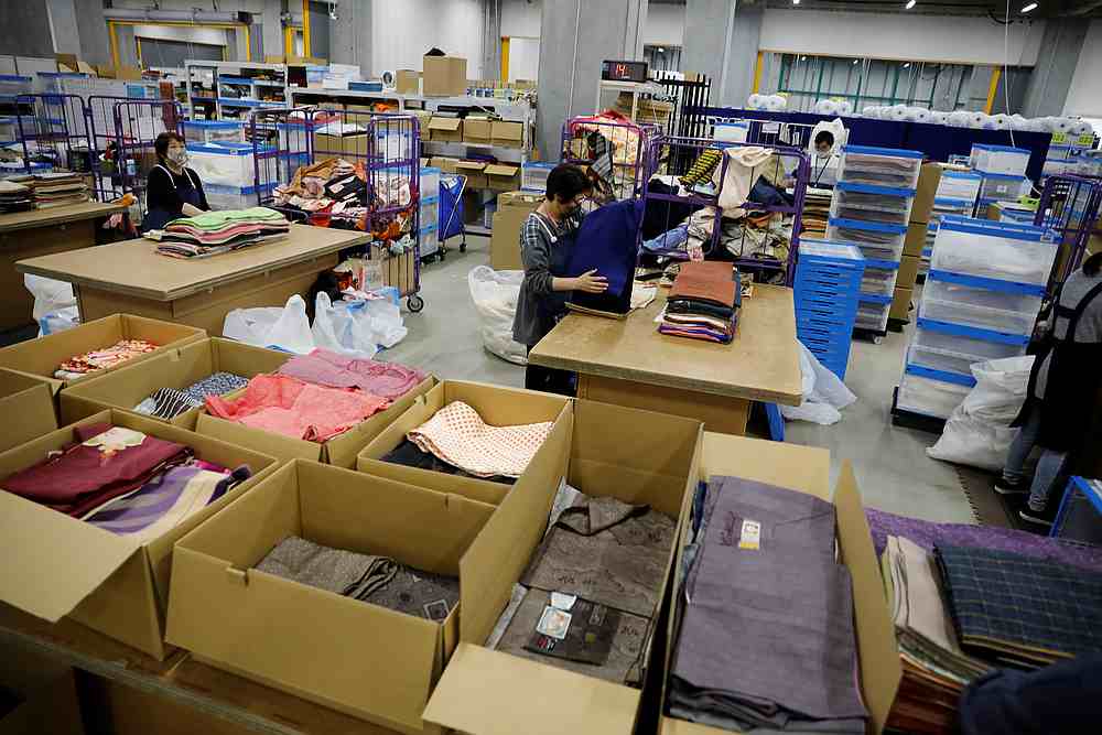 Workers of Buysell Technologies sort kimonos bought from private sellers at their warehouse in Funabashi, Chiba Prefecture, Japan, December 8, 2020. 