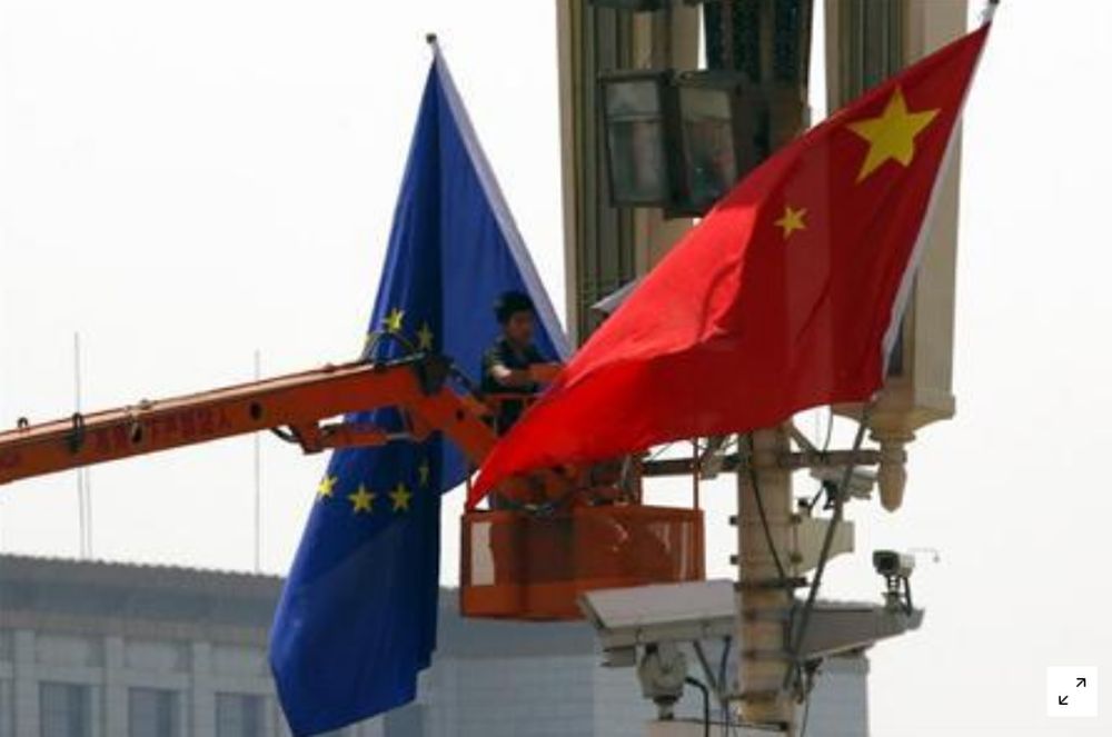 A worker on a cherry picker hangs a European Union flag next to a Chinese national flag at Beijingu00e2u20acu2122s Tiananmen Square in Beijing May 16, 2011. u00e2u20acu201d Reuters pic