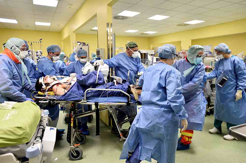 Multiple members of medical staff in protective suits are needed to move an 18-year old Covid-19 patient in an intensive care unit at the San Raffaele hospital, in Milan, Italy, March 27, 2020. u00e2u20acu201d Reuters pic