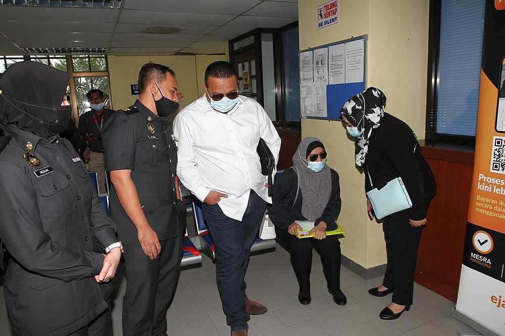 Raihanah Cold Storage Sdn Bhd director Rahman Sheik Abdullah (third from left) and his wife Raihanah Kasim (fourth from left) before the proceedings at the Sessions Court in Johor Baru December 30, 2020. u00e2u20acu201d Picture by Ben Tan