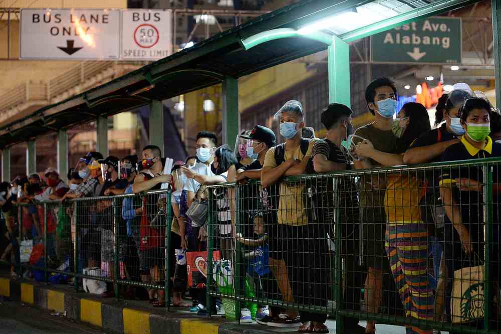 People wearing face masks and face shields as protection against Covid-19 queue at a bus stop, in Quezon City, Metro Manila Philippines, December 23, 2020. u00e2u20acu201d Reuters pic