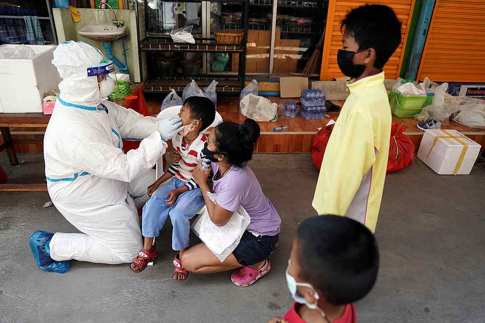 A healthcare worker takes a nasal swab sample of a child for a Covid-19 test at a migrant community, amid the Covid-19 outbreak, in Samut Sakhon province, in Thailand December 20, 2020. u00e2u20acu201d Reuters pic