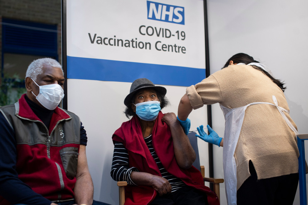Lorna Lucas, 81, reacts as she receives the first of two Pfizer/BioNTech Covid-19 vaccine jabs shortly before her husband, Winston (left) also has one administered at Guyu00e2u20acu2122s Hospital, in central London December 8, 2020. u00e2u20acu201d AFP picnn