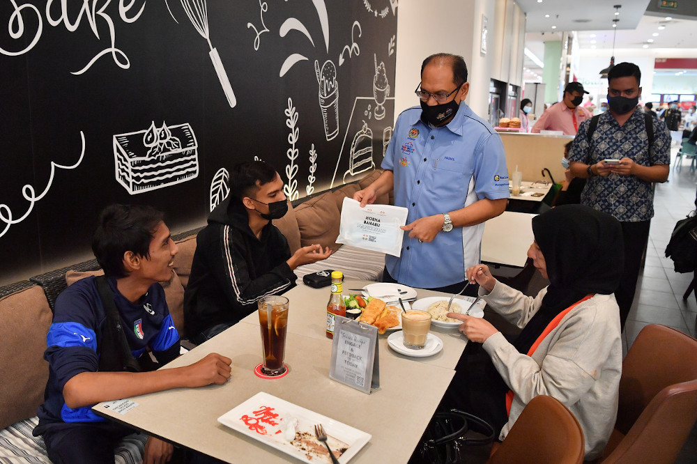 Domestic Trade and Consumer Affairs Ministry secretary-general Datuk Seri Hasnol Zam Zam Ahmad handing out new norm kit to visitors at AEON Cheras Shopping Center December 10, 2020. u00e2u20acu201d Bernama picn