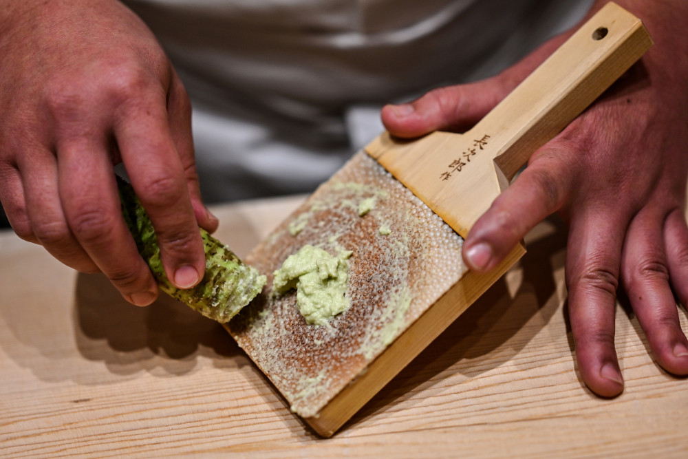 In this picture taken December 1, 2020, Japanese sushi master Toshiya Matsushita shreds fresh wasabi at his restaurant in Tokyo. — AFP pic