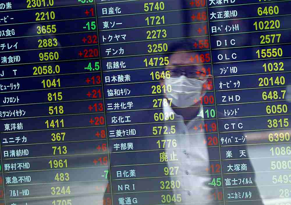 A man wearing a protective face mask is reflected on a stock quotation board at a brokerage, amid the Covid-19 outbreak, in Tokyo, Japan November 6, 2020. u00e2u20acu201d Reuters pic