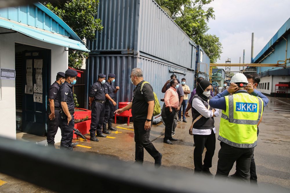 Enforcement officers are pictured during a raid on the premises of a glove manufacturer in Klang December 24, 2020. — Picture by Yusot Mat Isa